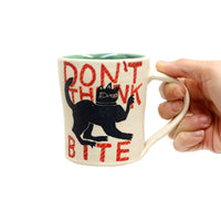Don't Think, Bite Mug by Paula Weiss